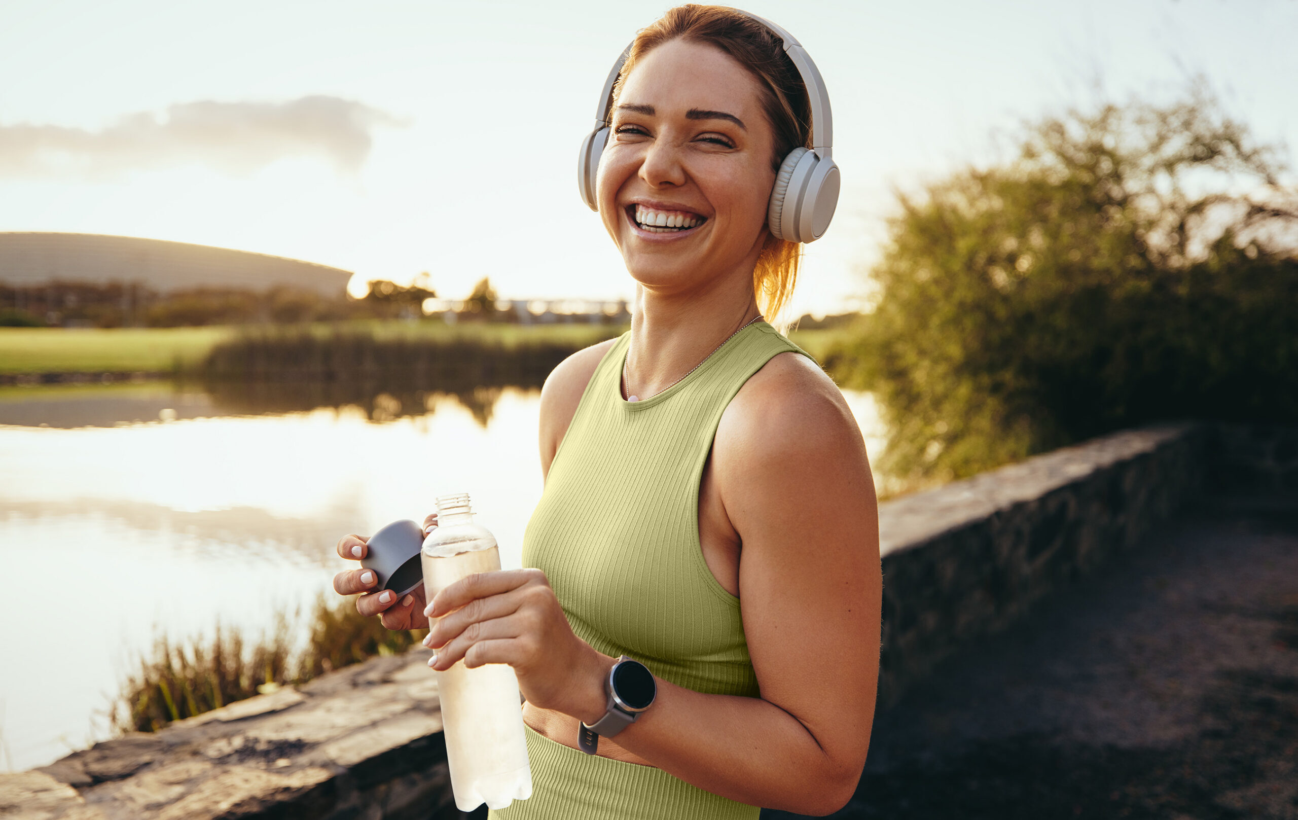 WomanWater A woman wearing headphones and holding a bottle of water